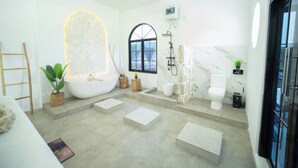 A modern bathroom with a freestanding bathtub, a shower, a toilet, and a vanity. - Rehat at D'Sawah Villas (Rancakalong)