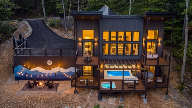 A multi-level cabin with a deck, a fire pit, and a swimming pool. - Luxe Cabin with Heated Indoor Pool, Hot Tub, Arcade & Theater near Dollywood (Sevierville)