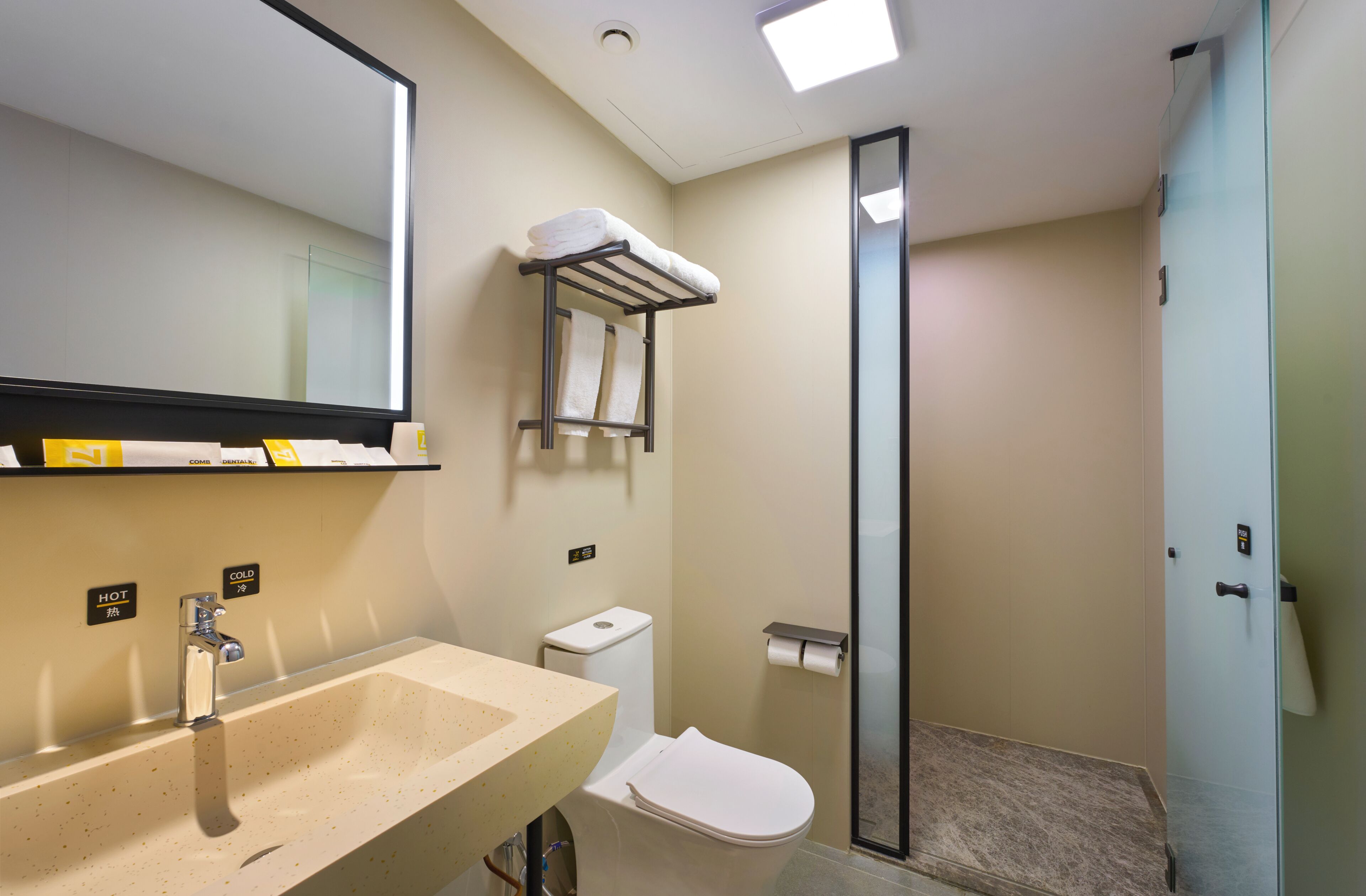 A modern bathroom with a sink, toilet, and a glass shower enclosure.