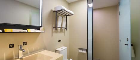 A modern bathroom with a sink, toilet, and a glass shower enclosure.