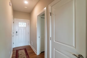 A hallway with a white door, a window with a grid pattern, and a wooden floor. - Mountain Views Retreat | Retreat for 2 | Breathtaking Scenery | Firepit (Clarkesville)