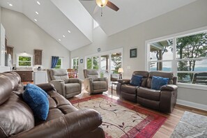 Ein geräumiges Wohnzimmer mit Ledersofas, einem Essbereich und einer Küche.