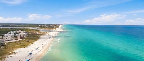 Propiedad costera con playa, vista al océano y edificios colindantes.