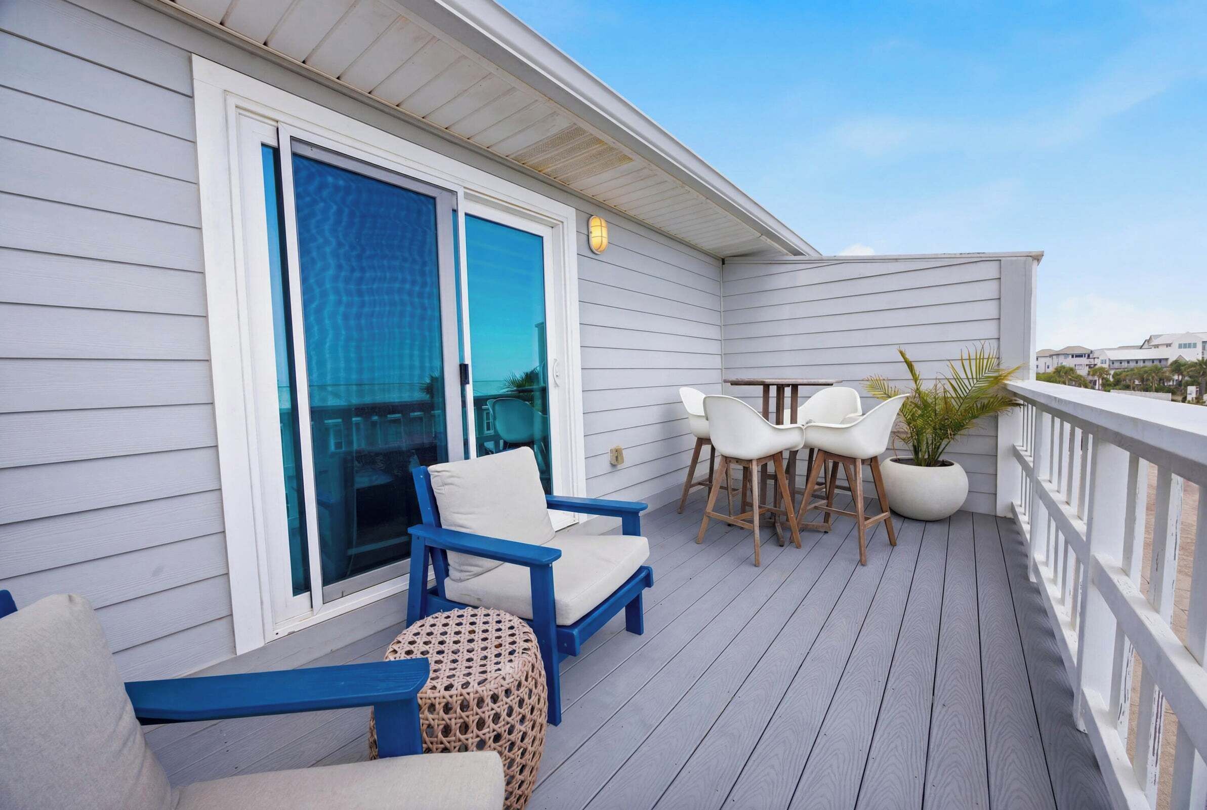 Eine überdachte Terrasse im Freien mit Sitzgelegenheit, Tisch und Topfpflanze.