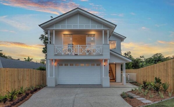 A two-story house with a balcony, a garage, and a wooden fence surrounding the property. - WELCOME HOME (Chapel Hill)