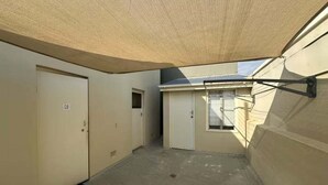 A covered outdoor area with a door, a window, and a wall-mounted rack. - City Loft | Stylish CBD Stay + River Walks (Rockhampton)