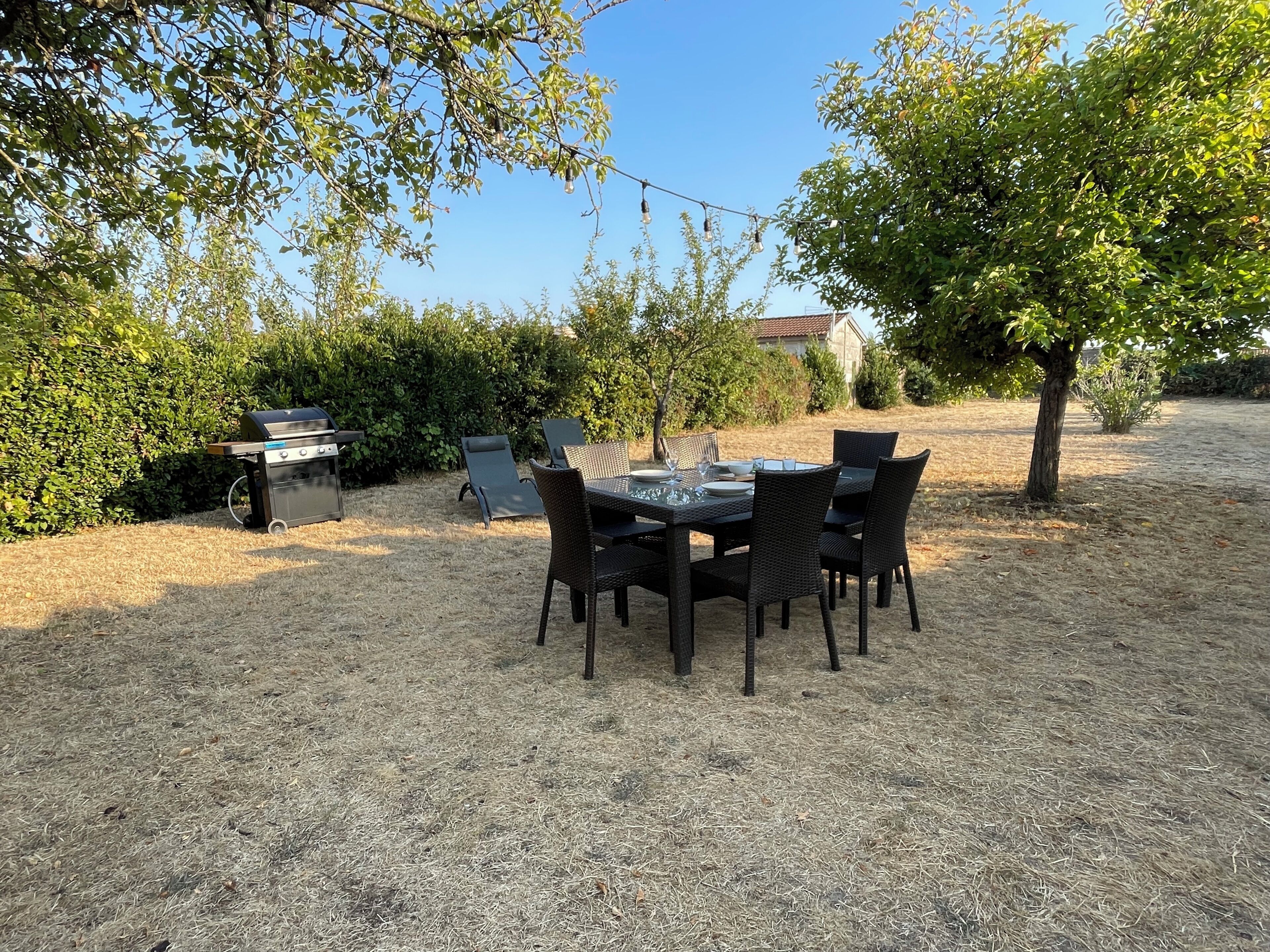 An outdoor dining area with a grill and chairs.