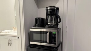 Une cuisine compacte équipée d’un four à micro-ondes, d’une machine à café et d’un grille-pain.