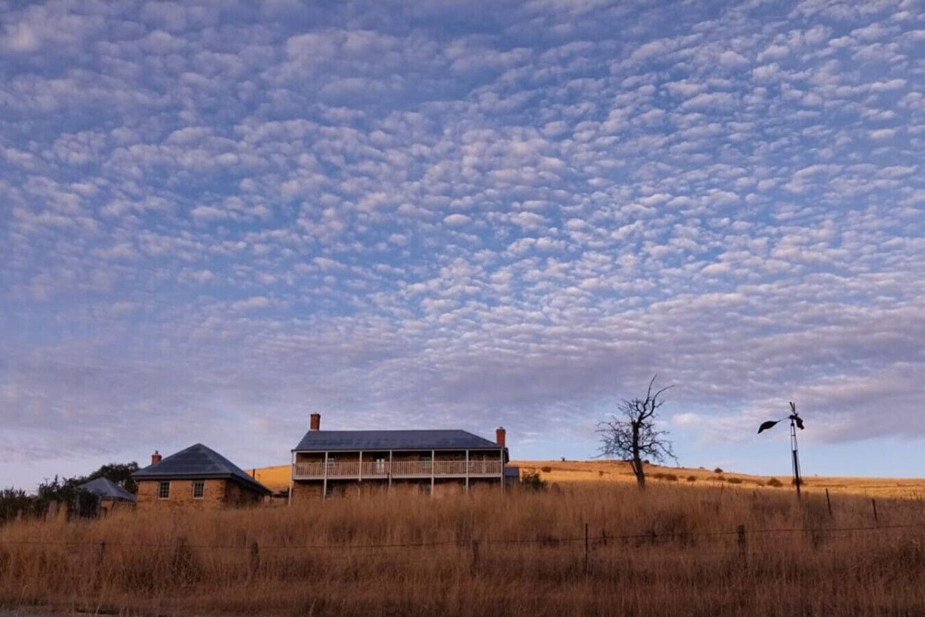 A house with a large porch and a clear sky.