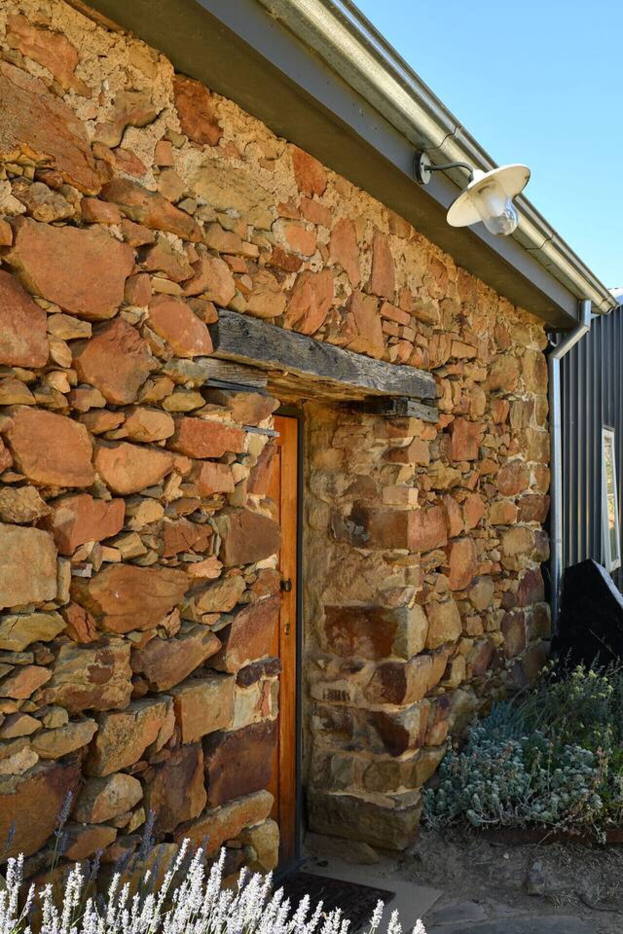 A stone building with a wooden door and a satellite dish.