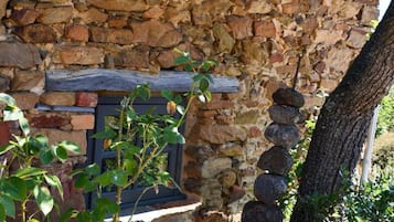 A stone building with a wooden door and a stone wall.