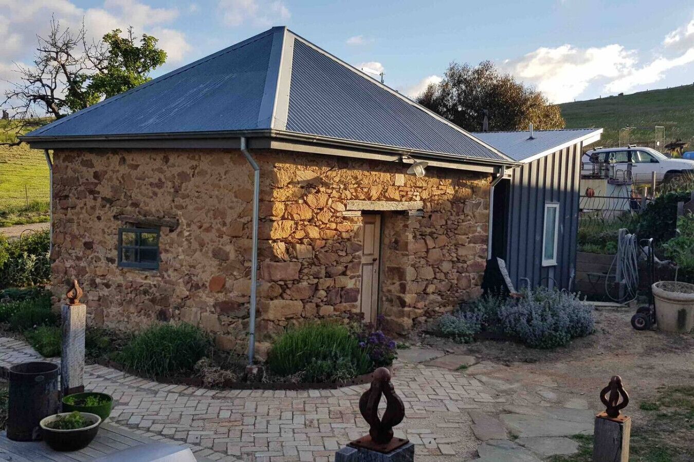 A stone building with a metal roof, a door, and a small window.