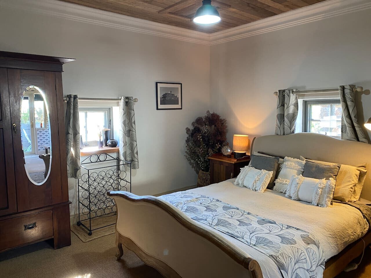 A bedroom with a bed, dresser, and a mirror.