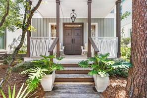 A porch with a double door, white railings, and steps leading to a wooden deck. - Amos Cottage in Rosemary Beach - bikes, pools, and much more! (Inlet Beach)