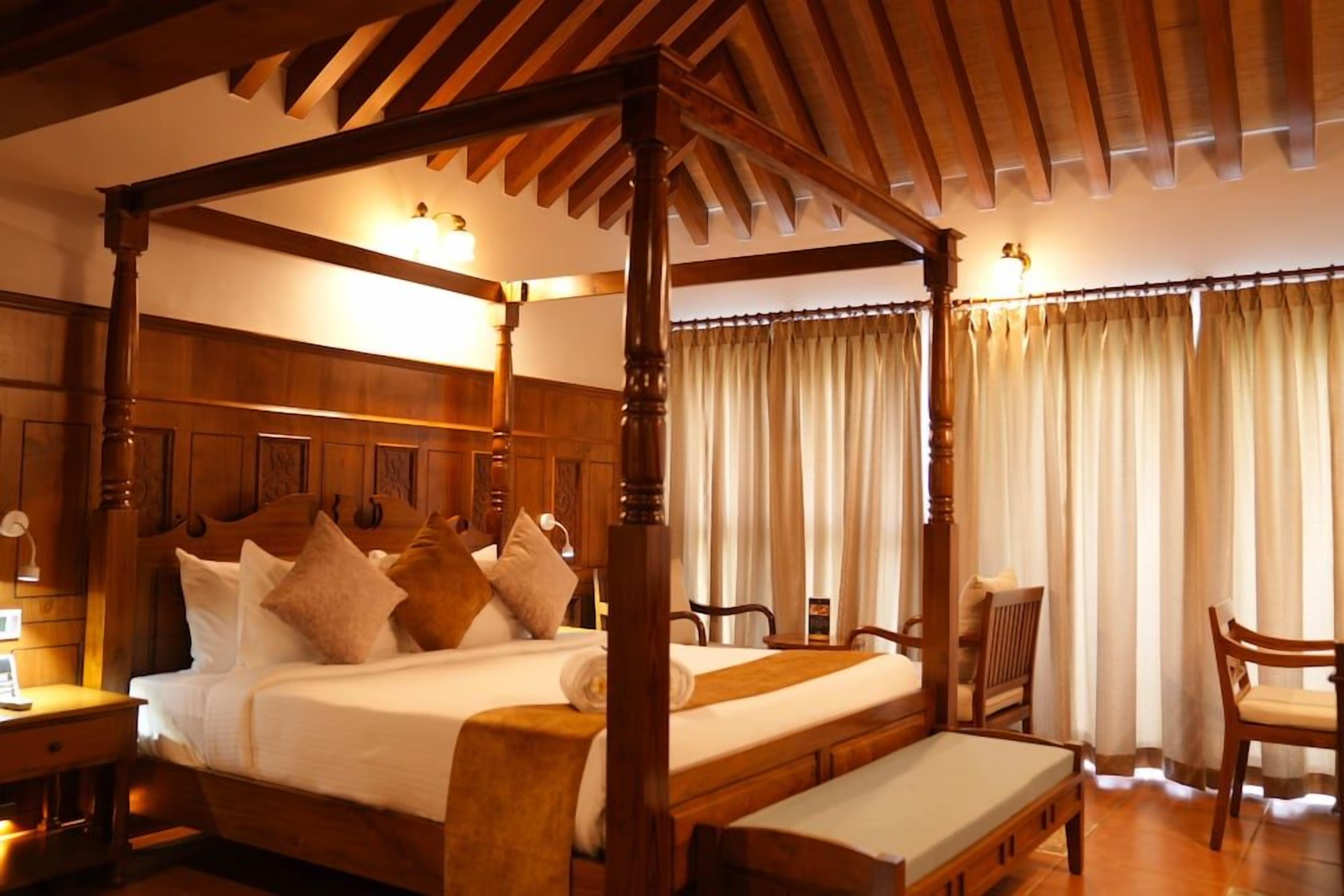 Uma cama com dossel, com cabeceira de madeira, mesa de cabeceira e uma cadeira.