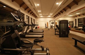 A gym with treadmills, elliptical machines, and weightlifting equipment. - Gokulam Grand Resort and Spa Kumarakom (Kottayam)