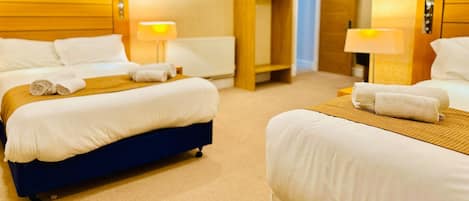 Habitación de hotel con dos camas, un armario y baño.