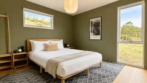 A bedroom with a bed, nightstands, a window with a view, and a framed picture on the wall. - Moonrise by Ready Set Stay (Harcourt North)