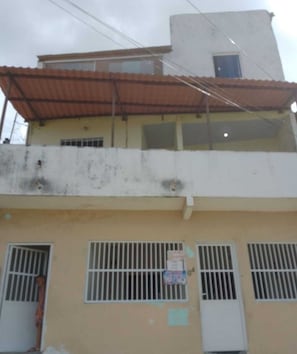 Un edificio a due piani con grate alle finestre e un balcone ben visibile.