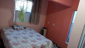 A bedroom with a bed, a window, and an air conditioning unit.
