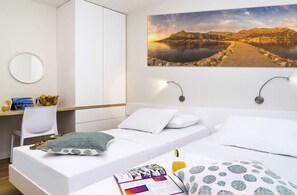 A hotel room with a bed, a desk, a chair, a round mirror, and a wall-mounted picture. - Villa Jadranka - Private villa with pool (Borak)
