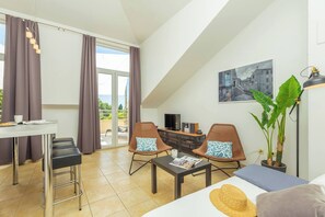 A modern living room with a dining area, a TV, and a large window with curtains. - Hedera Estate, Hedera A1 (Dubrovnik)