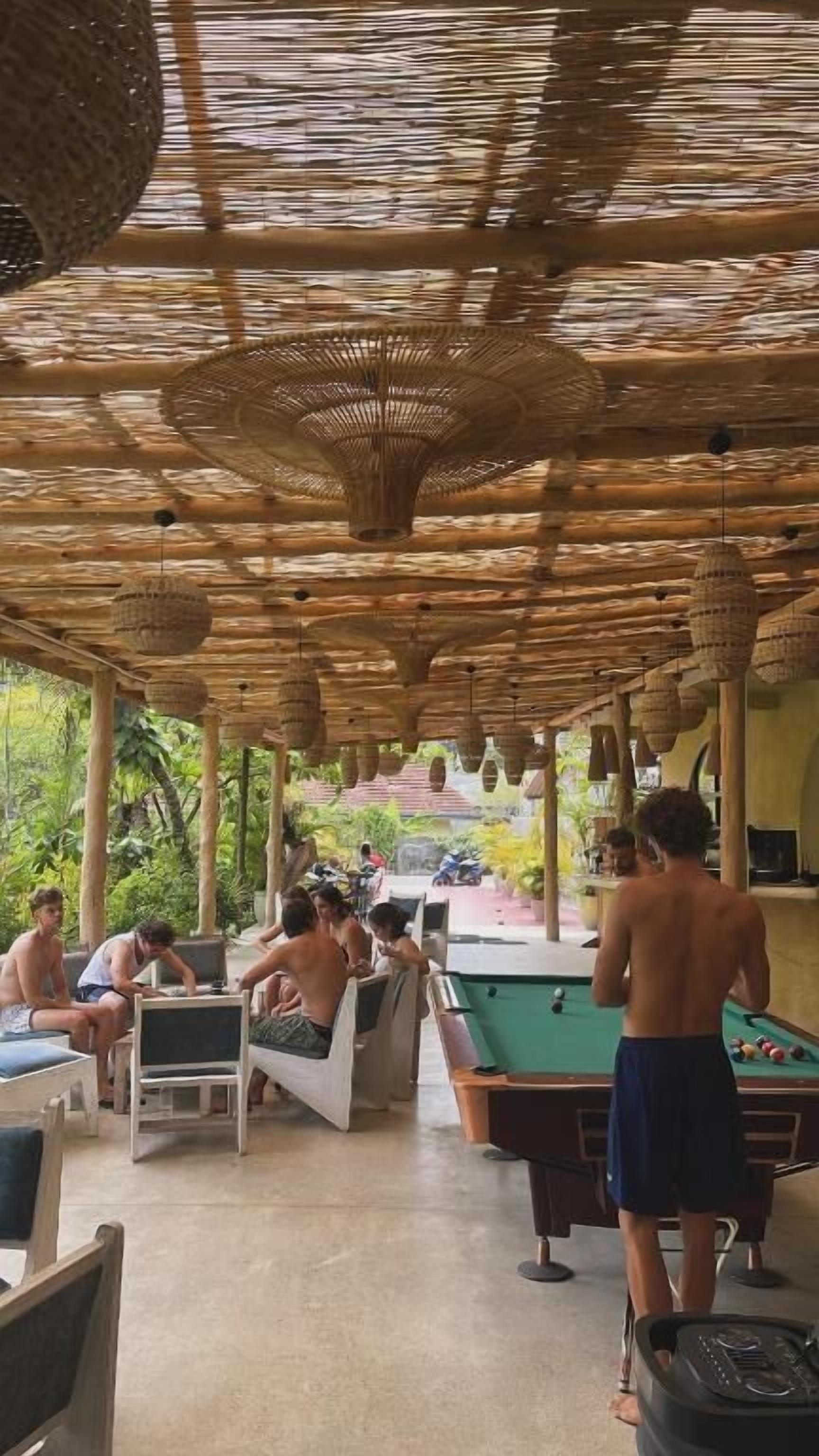An outdoor pool area with lounge chairs and a pool table.