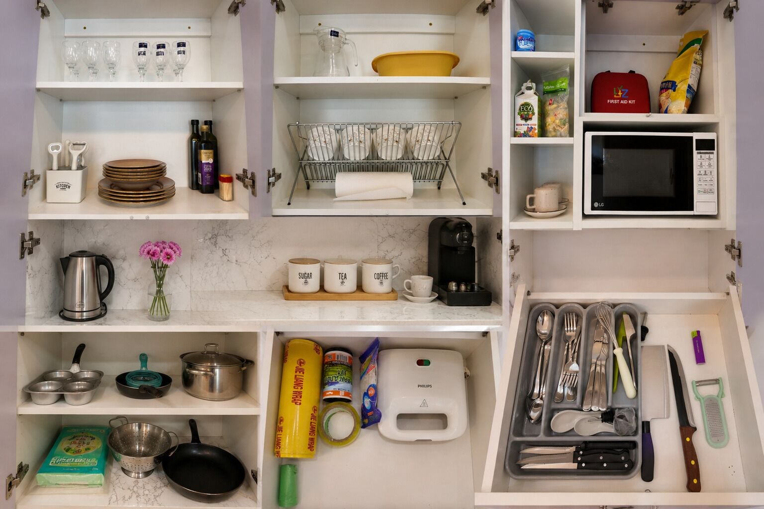 A kitchen with various utensils, a coffee maker, and a microwave.