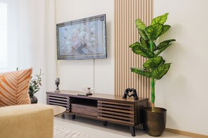 A living room with a sofa, a console table with decorative items, a potted plant, and a framed artwork on the wall. - City views (Nairobi)
