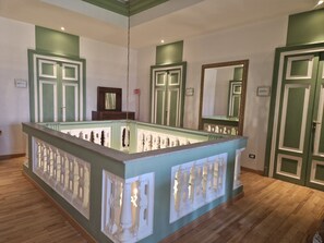 Una habitación con una isla central, suelo de madera y paredes pintadas de verde.