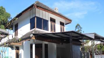 A two-story house with a covered porch and a blue table.