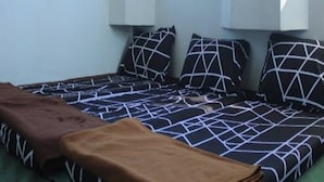 Quarto com cama, janela e ar-condicionado fixado na parede.