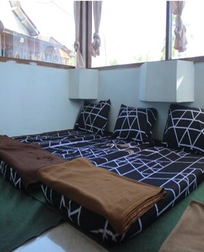 A room with a bed, a window, and a wall-mounted air conditioning unit. - Cozzy Harys Farm Pangalengan (Pangalengan)