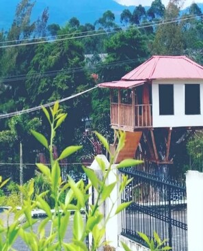 Un edificio de dos pisos con techo rojo y balcón.