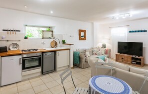 A compact living space with a kitchenette, a dining area, and a seating area with a television. - Gorgeous home in Montferrand-du-Périgor (Montferrand-du-Périgor)