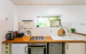 A compact kitchen with a gas stove, a sink, a small refrigerator, and a window with a view of greenery. - Gorgeous home in Montferrand-du-Périgor (Montferrand-du-Périgor)