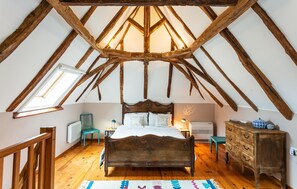 A bedroom with a sloped ceiling, a wooden bed, a dresser, and a radiator. - Gorgeous home in Montferrand-du-Périgor (Montferrand-du-Périgor)