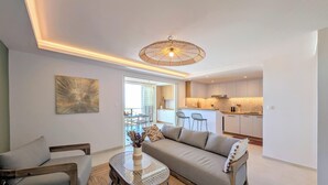 A modern living room with a sofa, chairs, a coffee table, and a dining area with chairs and a table. - Vrbo Property (Saint-Paul)