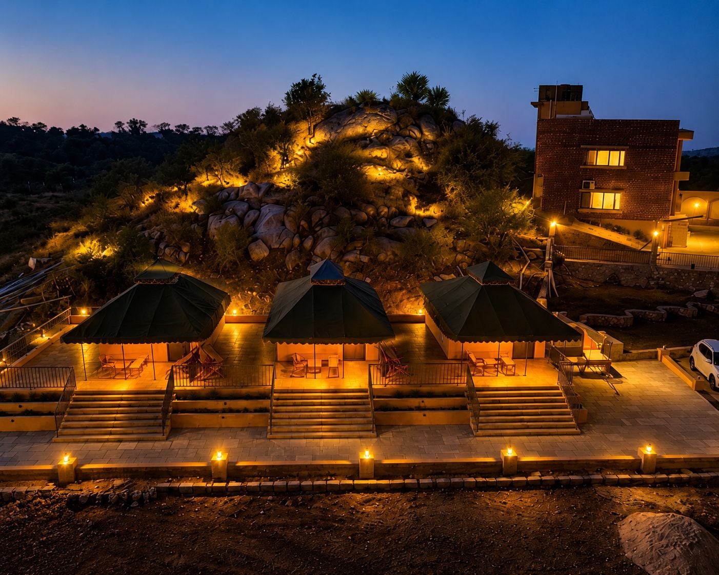 Un hotel con zonas de estar al aire libre, escalones que conducen a la entrada y un edificio con ventanas.