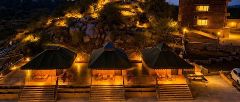 Un hotel con zonas de estar al aire libre, escalones que conducen a la entrada y un edificio con ventanas.