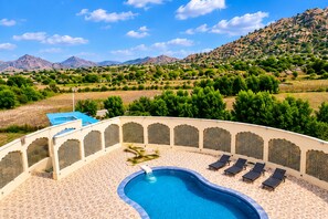 A pool area with a view of a mountainous landscape.