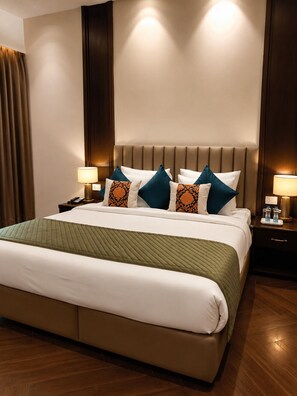A hotel room with a large bed, two bedside tables, and a headboard with built-in lighting. - Moksha Resort and Spa  (Kapur Pind)