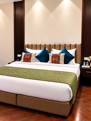 A hotel room with a bed, a nightstand, and a wall-mounted light. - Moksha Resort and Spa  (Kapur Pind)
