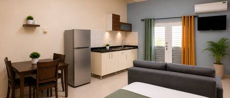 A compact living space with a kitchenette, a dining area, and a sofa.