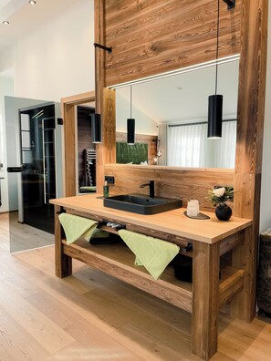 A wooden vanity with a black sink, a mirror, and a green towel. - Altstadt-Hotel Freiberg - Wellness (Freiberg)