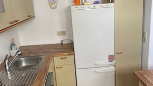 Eine kleine Küche mit Spüle, Herd und einem weißen Kühlschrank.