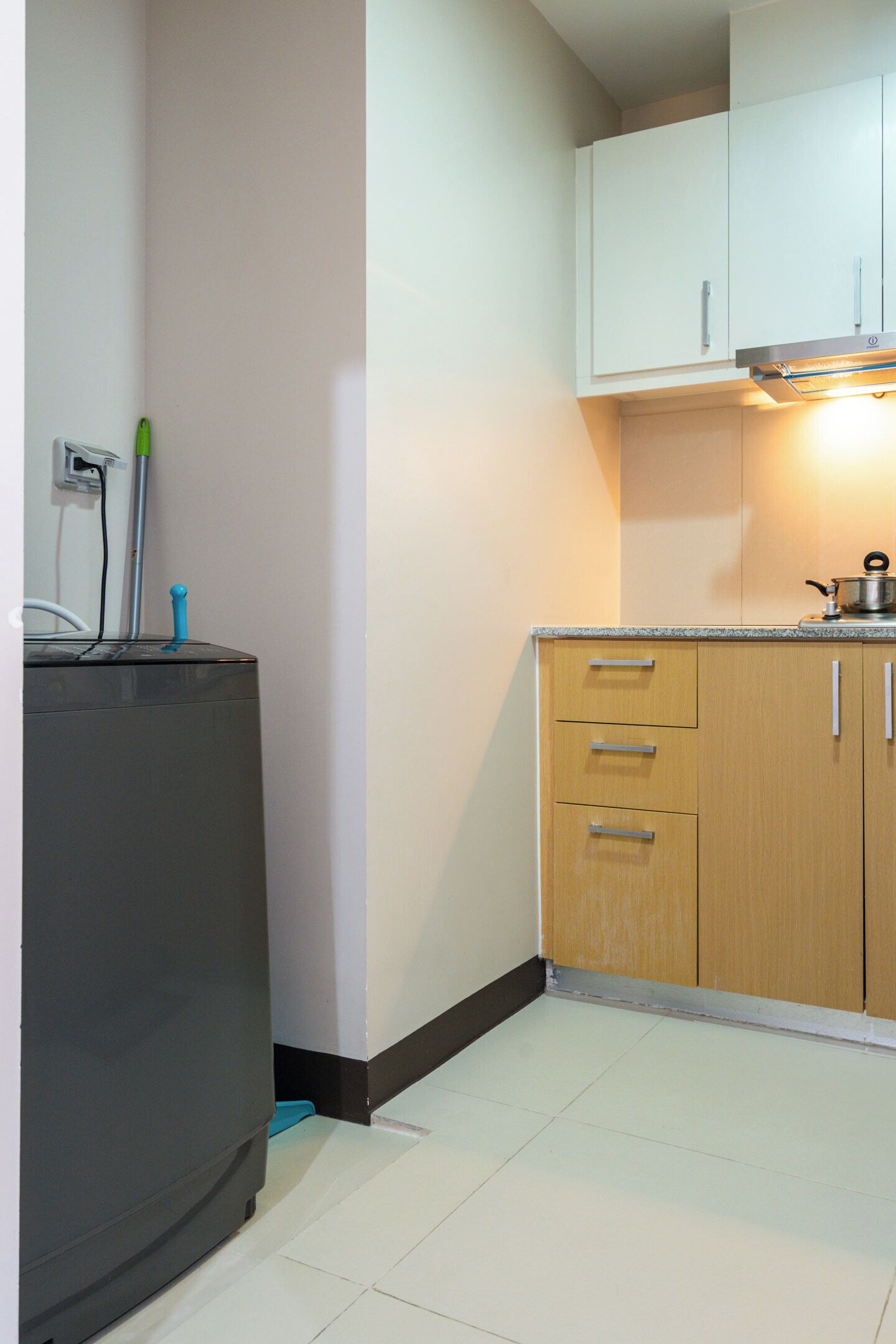 A small kitchen with white cabinets, a countertop, and a stove.