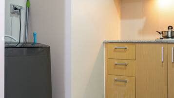 A small kitchen with white cabinets, a countertop, and a stove.