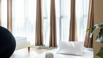 Une chambre d’hôtel avec un lit, une sculpture faite de serviettes et une plante.