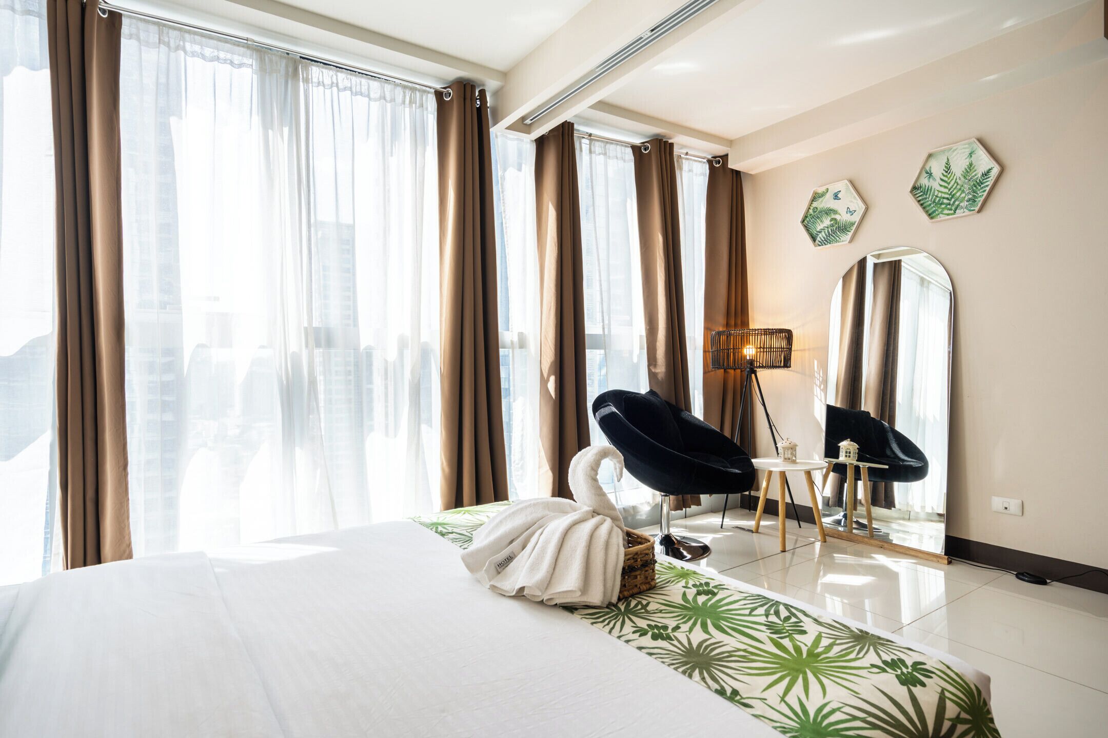 Une chambre d’hôtel avec un grand lit, une chaise, une lampe et un miroir.